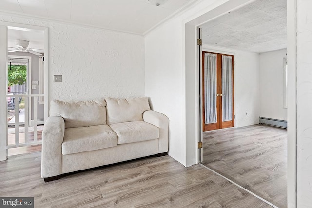 living room with french doors, ornamental molding, ceiling fan, a baseboard radiator, and hardwood / wood-style floors