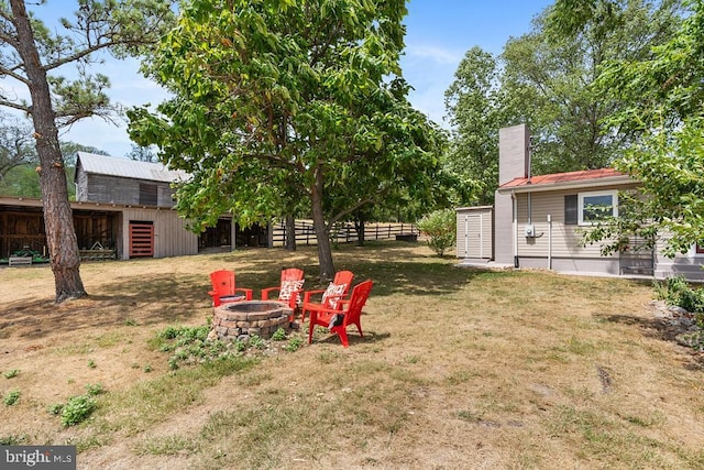 view of yard with an outbuilding and an outdoor fire pit