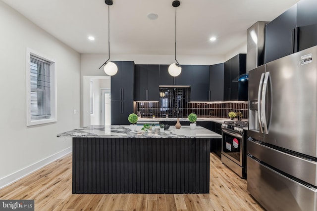 kitchen with pendant lighting, a kitchen island, light stone countertops, and appliances with stainless steel finishes