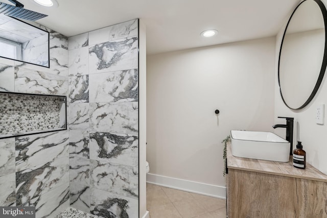 bathroom featuring a tile shower, vanity, toilet, and tile patterned floors