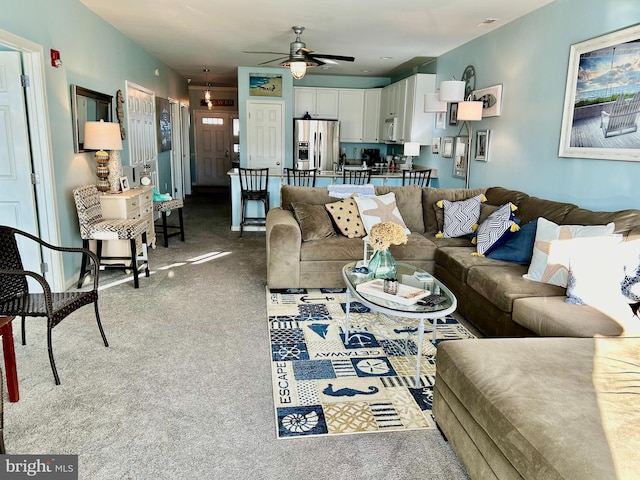 carpeted living room with ceiling fan