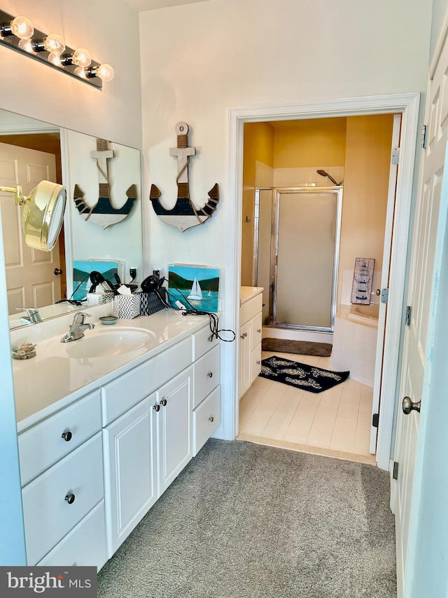 bathroom with walk in shower, vanity, and tile patterned floors