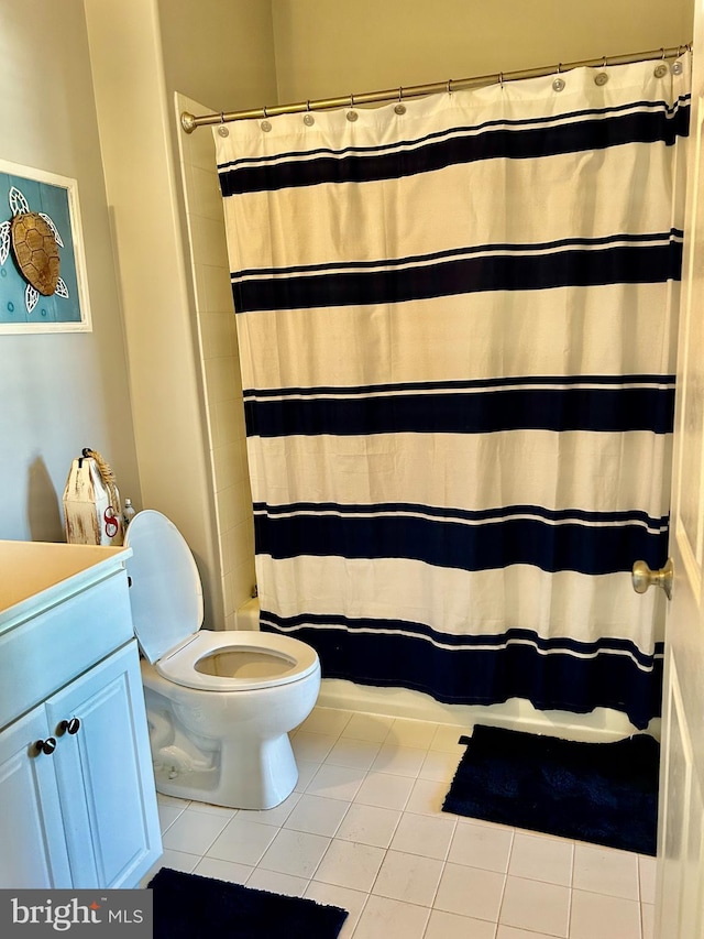 bathroom featuring toilet, vanity, tile patterned flooring, and curtained shower