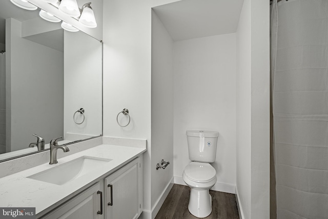 bathroom featuring toilet, vanity, and hardwood / wood-style flooring