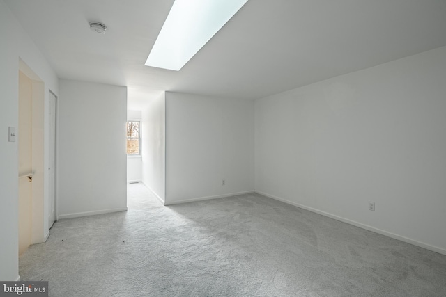 carpeted empty room with a skylight