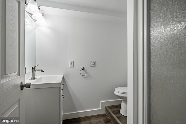 bathroom featuring wood-type flooring, vanity, and toilet