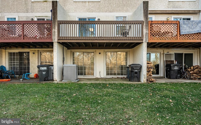 back of house featuring a lawn and central AC