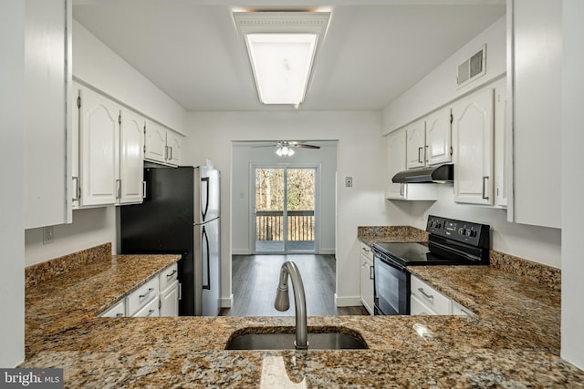 kitchen with black range with electric stovetop, sink, dark stone countertops, stainless steel fridge, and white cabinets