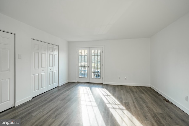 interior space featuring french doors, multiple closets, and dark wood-type flooring