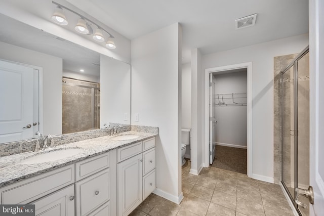 bathroom featuring tile patterned floors, toilet, and walk in shower