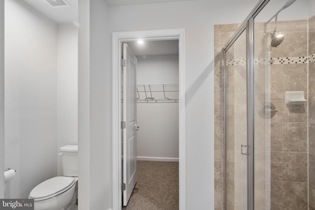 bathroom featuring toilet and an enclosed shower