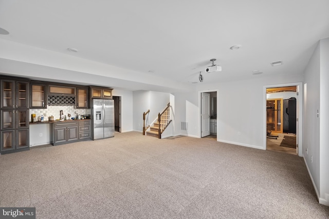 unfurnished living room with light carpet and indoor bar