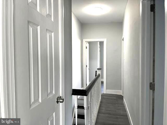 corridor with dark hardwood / wood-style flooring