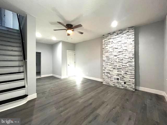 unfurnished living room featuring dark hardwood / wood-style flooring and ceiling fan