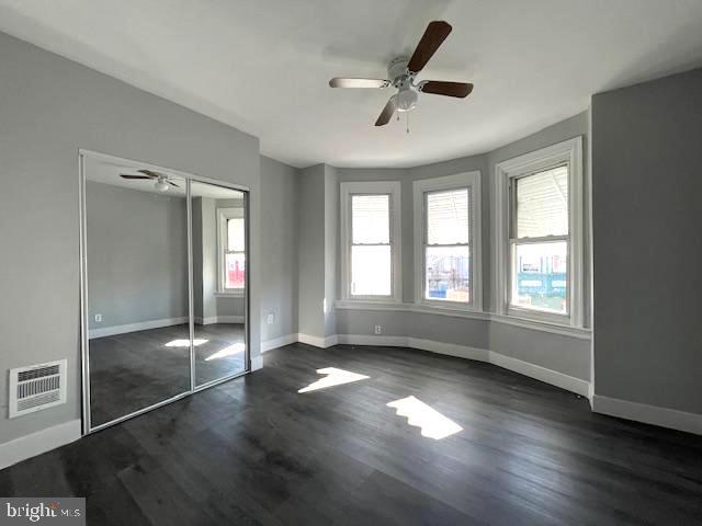 unfurnished bedroom featuring ceiling fan, a closet, and dark hardwood / wood-style floors