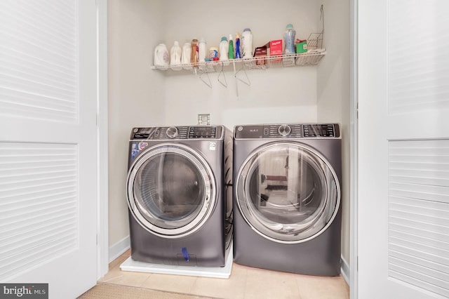 laundry area featuring washer and dryer and light tile patterned flooring