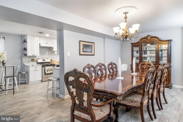 dining space featuring a chandelier and light wood-type flooring