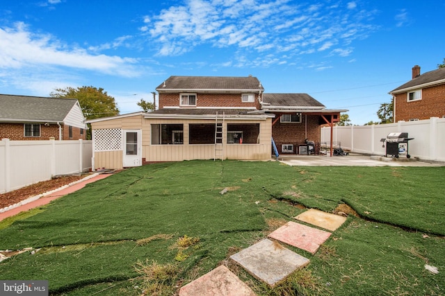 back of property with a patio area and a yard