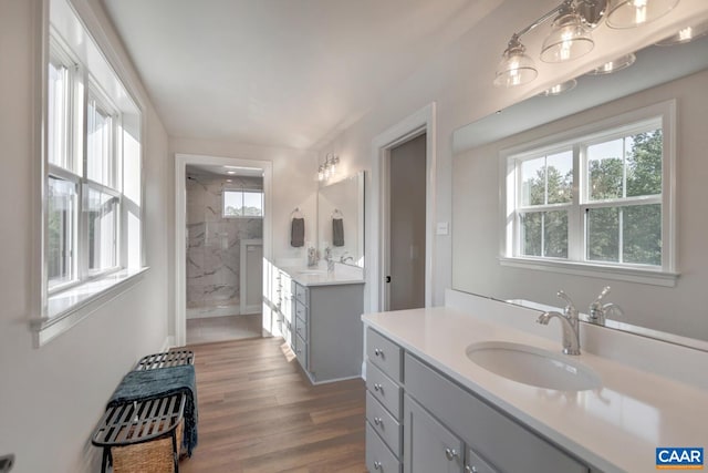 bathroom featuring vanity, wood-type flooring, and tiled shower