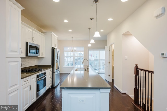 kitchen with backsplash, dark wood-style floors, stainless steel appliances, and a sink