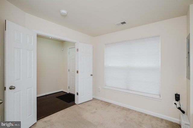 unfurnished room with carpet floors, visible vents, and baseboards