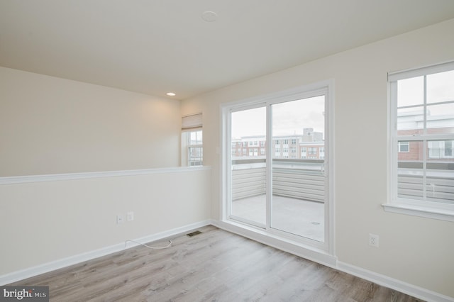 empty room with recessed lighting, visible vents, light wood-style flooring, and baseboards