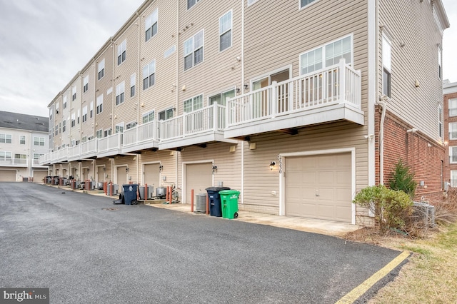 view of building exterior featuring a garage and central AC unit