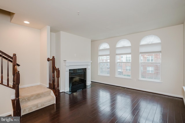 living room featuring stairs, wood finished floors, and a wealth of natural light