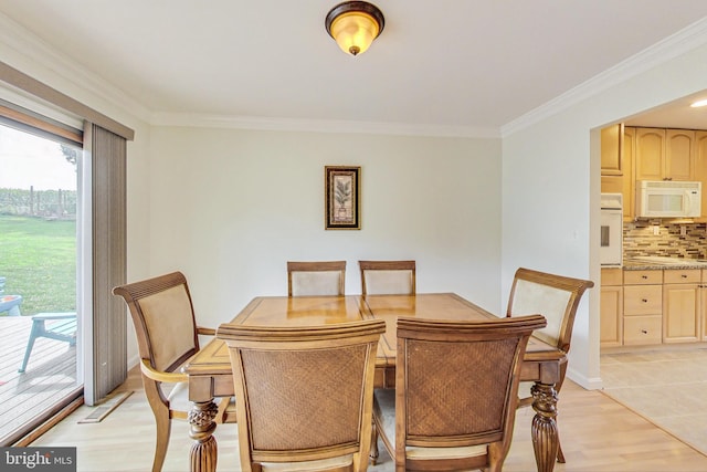 dining space with light hardwood / wood-style floors and ornamental molding