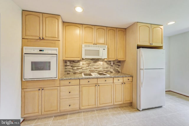 kitchen with light brown cabinets, white appliances, light stone countertops, tasteful backsplash, and light tile patterned flooring