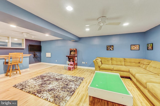 living room featuring wood-type flooring and ceiling fan