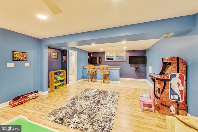 playroom with hardwood / wood-style flooring and bar