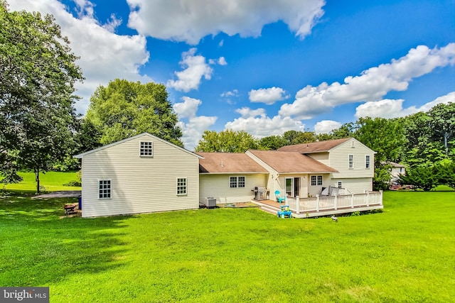 rear view of property with a wooden deck, a yard, and cooling unit