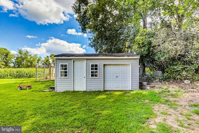 view of outdoor structure with a garage and a lawn