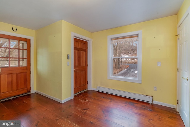 foyer entrance with baseboard heating, a wealth of natural light, and dark hardwood / wood-style floors