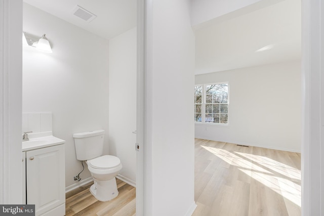 bathroom featuring vanity, hardwood / wood-style floors, and toilet
