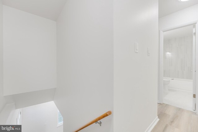 bathroom featuring hardwood / wood-style flooring, shower / bathtub combination, and toilet