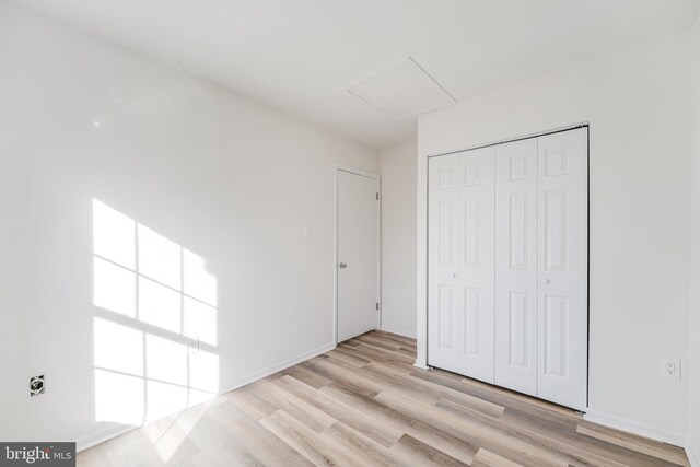 unfurnished bedroom with light hardwood / wood-style floors and a closet