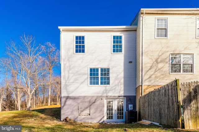 rear view of house featuring french doors and a lawn