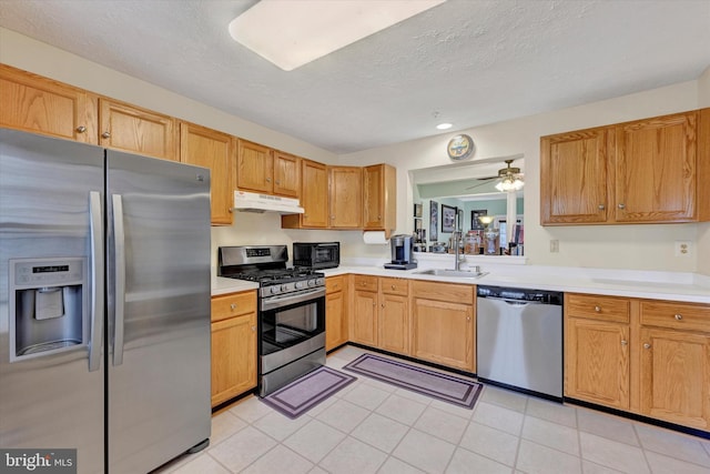 kitchen with appliances with stainless steel finishes, a textured ceiling, ceiling fan, sink, and light tile patterned floors