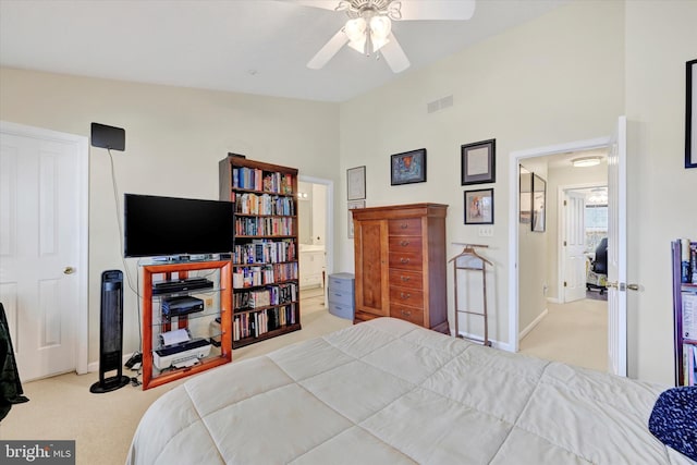 bedroom featuring light carpet, ensuite bathroom, vaulted ceiling, and ceiling fan