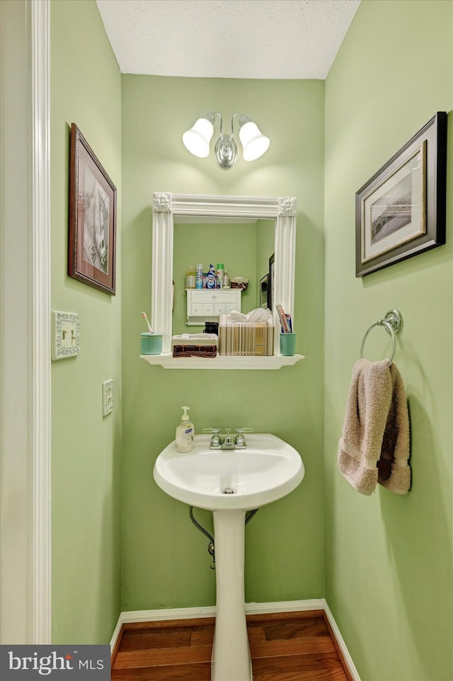 bathroom with a textured ceiling and hardwood / wood-style flooring