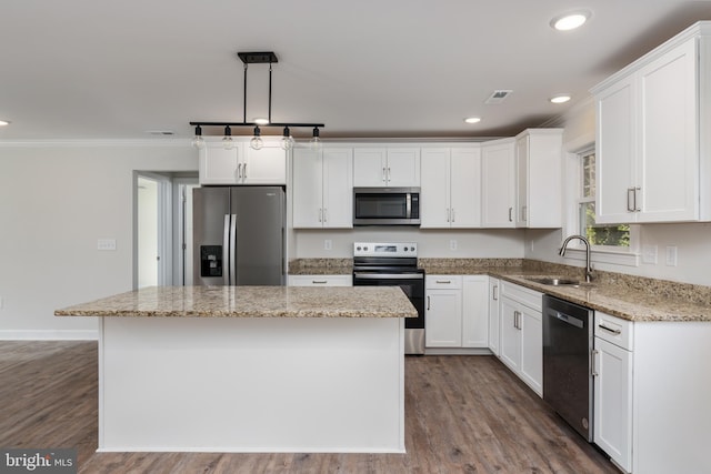 kitchen with appliances with stainless steel finishes, white cabinetry, a center island, and sink