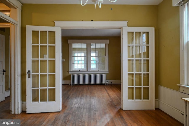 doorway featuring radiator heating unit, french doors, and hardwood / wood-style floors