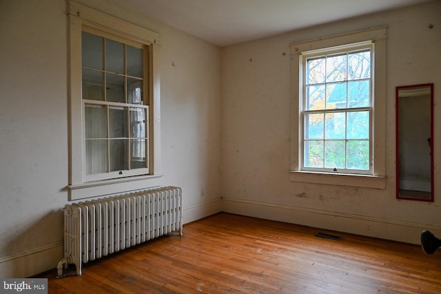 empty room with radiator heating unit and wood-type flooring