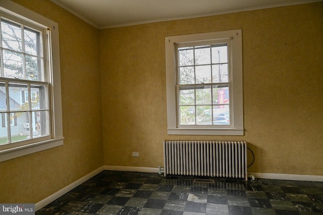 unfurnished room with radiator, crown molding, and plenty of natural light