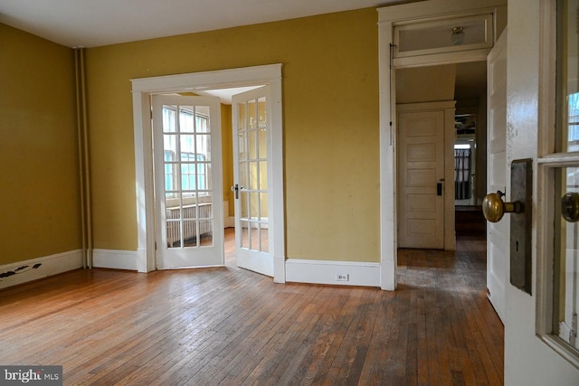 empty room with french doors and hardwood / wood-style flooring