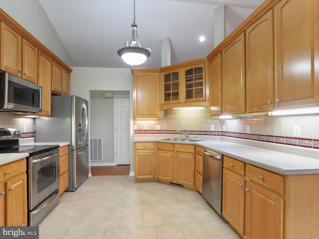 kitchen with decorative backsplash, sink, lofted ceiling, and appliances with stainless steel finishes