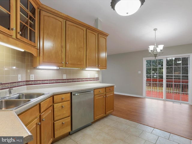 kitchen featuring dishwasher, light wood-type flooring, backsplash, and an inviting chandelier