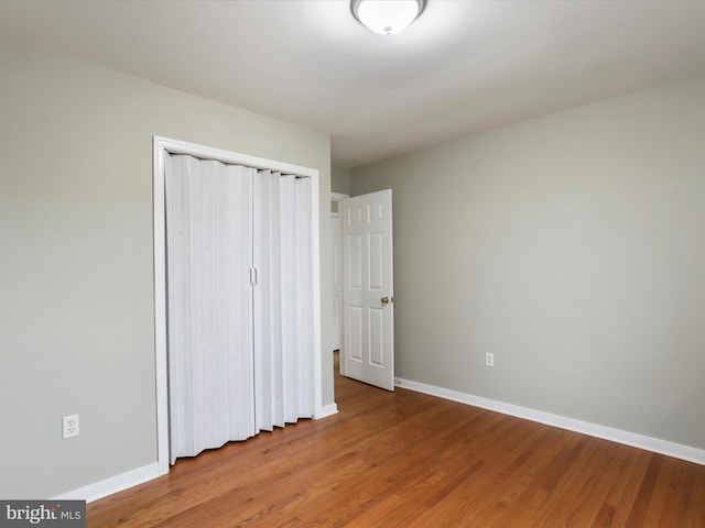 unfurnished bedroom with hardwood / wood-style flooring and a closet